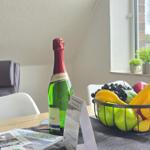 Table with bottle, fruit bowl, and brochures by window