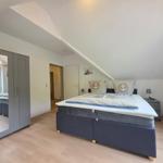 Bedroom with double bed, wardrobe, and sloped ceiling.