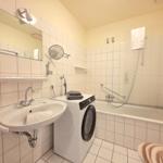 Bathroom with washing machine, shower, and mirror