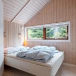 Bedroom with bed, window, and wooden wall