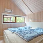 Bedroom with wooden walls, bed, and window to the garden
