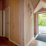 House with wooden walls, door, and glass door to the garden
