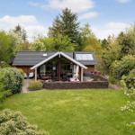A wooden house with a large garden and terrace in the greenery.