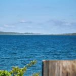 View of the sea with green landscape in the background.
