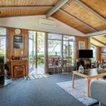 Living room with fireplace, large windows, and view of the lake.