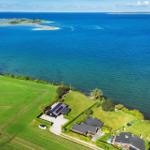 House by the sea with green field and view of the island.