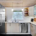 Kitchen with stainless steel fridge and dishwasher, wooden ceiling, and window with outside view.