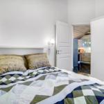 Bedroom with bed, nightstand, and wardrobe. Corridor to kitchen visible.