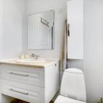Bathroom with sink, mirror, toilet, and window