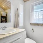 Bathroom with sink, mirror, and window with curtain.