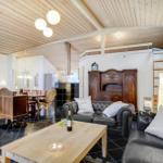 Living and dining area with wooden ceiling, leather sofa, and wooden table.