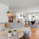 Living and dining area with sofa, table, chairs, and wooden floor.