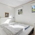 Bedroom with bed, dresser, and windows. Wooden ceiling and wall picture.