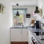 Kitchen with white cabinets, dark countertop, and window with view outside.
