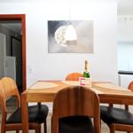 Esstisch mit vier Holzstühlen und Flasche Champagner