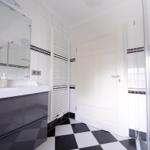 Badezimmer mit Dusche, Waschbecken und Heizkörper