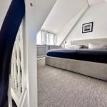 Schlafzimmer mit Dachschrägen, Bett und Fenster