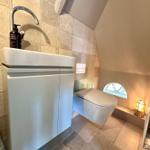 Badezimmer mit Waschbecken, WC und Fenster