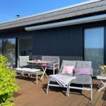 Liegen und Gartenmöbel auf der großen Holzterrasse