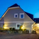 Haus mit Steinmauer, beleuchtet bei Dämmerung, Hausnummer 21