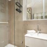 Dusche mit Glaswand, Waschbecken und Spiegel