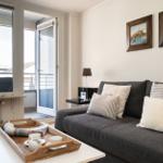 Wohnzimmer mit Sofa, Kissen und Blick auf Balkon