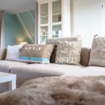 Ein Sofa mit Kissen und einer Decke im Wohnzimmer.