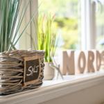Fensterbrett mit Korb, Pflanzen und Holzbuchstaben NORDSEE.