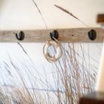 Holzstange mit Haken und Rettungsring an der Wand.