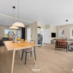 Entrance area with dining space and living room featuring hardwood flooring and modern furnishings.