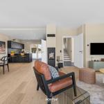 Living and dining area with kitchen, TV, and fireplace.