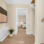 Hallway with staircase, wall art, and view into bedroom