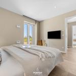 Bedroom with bed, TV, and view of outdoor area.