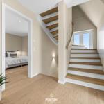 House with staircase and bedroom. Wooden steps and natural light.