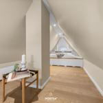 Bedroom with sloped ceiling, bed, and wooden floor