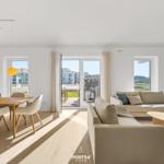 Living and dining area with view of terrace and beach.