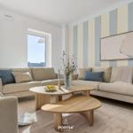 Living room with two sofas, wooden table, and striped wall.
