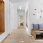 Hallway with wooden closet, bench, and wall decor.