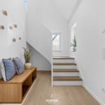 Staircase with wooden steps and bench under sloped ceiling