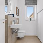 Bathroom with sink, toilet, and window.