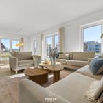Living area with sofa, coffee table, and windows for views.