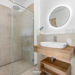 Bathroom with shower, sink, and mirror