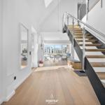 Haus mit Holzboden, Treppe und Essbereich mit Blick auf Gebäude.