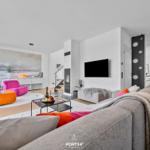 Wohnzimmer mit Sofa, Sitzgelegenheiten und Fernseher.