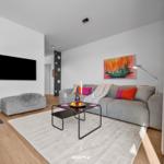 Wohnzimmer mit Sofa, Couchtisch und Fernseher an der Wand.