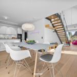 Moderne Küche mit Essbereich und Treppe zur oberen Etage.