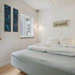 Bedroom with bed, windows, and wall decor.