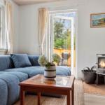 A living room with blue sofa, fireplace, and terrace door.