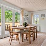 Dining room with wooden table, chairs, and view of terrace.
