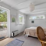 Bedroom with bed, chair, and view of the garden.